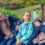 a group of women sitting next to each other on a bench