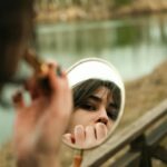 Woman looking at her reflection in mirror - build confidence fast